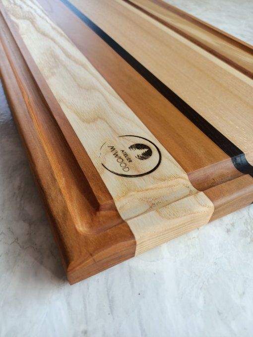 grande planche à découper en bois avec plusieurs essences et un récupérateur de jus pour la viance