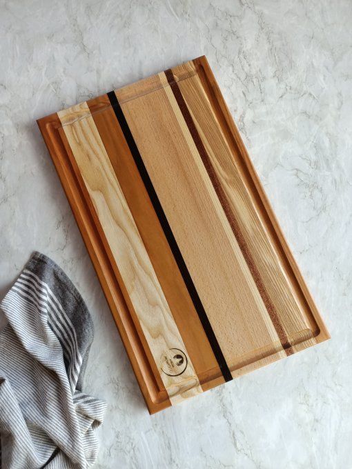 grande planche à découper en bois avec plusieurs essences et un récupérateur de jus pour la viance